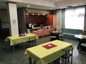 由良町Biz Hotel Kiiyura的一间带黄色桌椅的餐厅