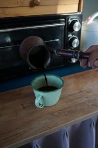 坎古Kultur Umalas - CHSE Certified的把咖啡倒进柜台上的碗里的人