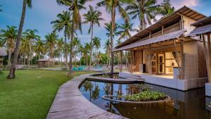 吉利美诺Pravasa Gili Resort by KajaNe的一座带游泳池和棕榈树的房子