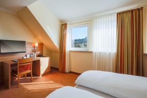 巴特司塔福斯坦班泽尔瓦尔德贝格酒店的配有一张床、一张书桌和一扇窗户的酒店客房