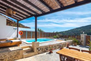 罗达奇诺Villa Cosmakis的一个带游泳池和木制凉亭的户外庭院