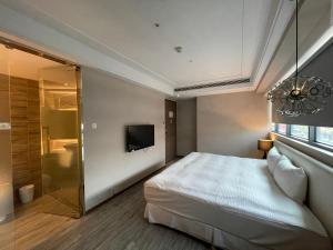 高雄好地方饭店六合馆的一间卧室配有一张床、淋浴和一台电视