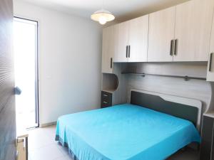 托雷圣乔万尼乌Acton Apartment Torre San Giovanni - Verso Sud的一间卧室配有蓝色的床和白色橱柜