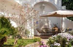 阿纳卡普里伊尔索格诺住宿加早餐酒店的庭院配有遮阳伞和桌椅。