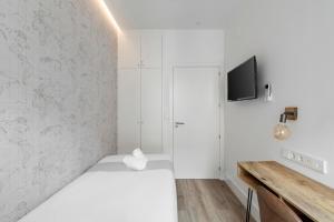 马德里Marco Polo Residence Hostal Boutique的一间卧室配有一张床,墙上配有电视