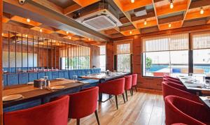 西里古里Treebo Trend Sky Point的用餐室配有桌子和红色椅子