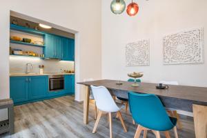 卡尔帕索斯Annika's Family House的厨房配有蓝色橱柜和木桌及椅子