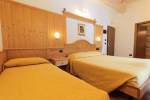 安达洛玛耀卡酒店的配有黄色床单的酒店客房的两张床