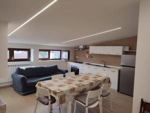 罗卡拉索Residenze Macerelli的厨房配有桌子和蓝色沙发