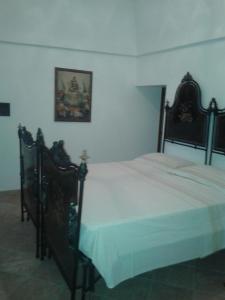 奥斯图尼villa ottocento的一间卧室配有一张带白色床单的大床