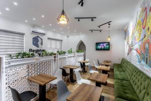 撒马尔罕Registan Hostel的餐厅设有桌椅和绿色沙发