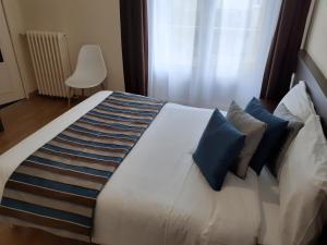阿朗松乐查普罗格酒店的卧室配有带蓝色枕头的大型白色床