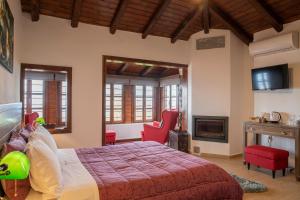 帕莱斯潘蒂雷蒙Guesthouse Ourania的一间卧室配有一张带红色椅子的床和壁炉
