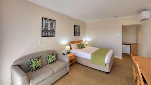 天鹅山Quality Inn Swan Hill的酒店客房,配有床和沙发