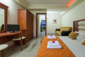 卡拉马孔Caretta Beach Resort & WaterPark的酒店客房 - 带一张床和一张带毛巾的书桌
