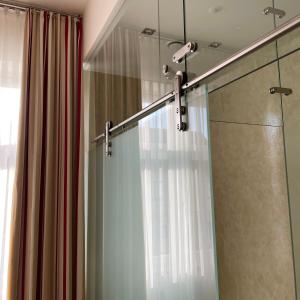 朗根洛伊斯维兹格尔霍夫酒店的淋浴间设有玻璃门和淋浴帘