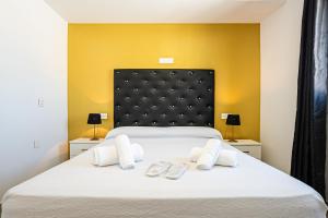 科尼尔-德拉弗龙特拉Apartamentos Turísticos La Boutique del Mar的卧室配有一张白色大床和2个拖鞋