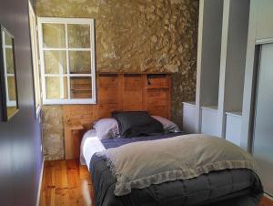 孔东Le Clot de Meste Duran的一间卧室设有一张床和石墙