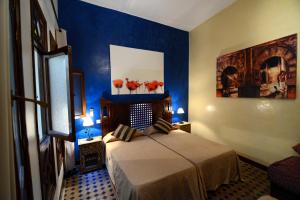 艾西拉阿斯拉里亚德酒店的一间设有床铺的卧室,位于一间拥有蓝色墙壁的房间
