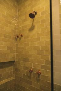 朱奎Øko Villa的配有黄色瓷砖墙和青铜器的淋浴