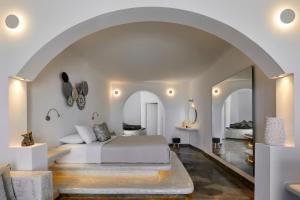梅加洛克里Suites of the Gods Cave Spa Hotel的一间卧室设有一张床和一个拱门