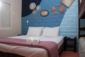 卡瓦坎特Chácara Lápis Lazuli的一间卧室设有蓝色的墙壁和一张带毛巾的床。