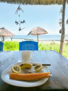 基林多尼Juani beach bungalows的桌上放有香蕉和热狗的盘子