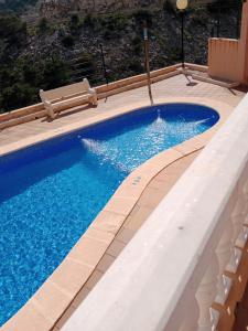 库列拉Villa de Mediterraneo Cullera的一座大型游泳池,铺有瓷砖地板,享有蓝色的海水