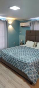 棕榈滩Lovely Cozy Keito的一间卧室设有一张蓝色墙壁的大床