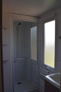 苏莱讷迪Camping La Croix Badeau的带淋浴和盥洗盆的浴室以及窗户。