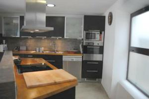 塔里法Apartamento El Cuarton的厨房配有水槽和炉灶 顶部烤箱