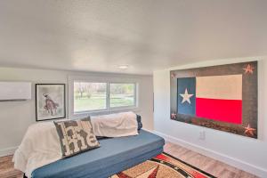 麦金尼Cozy McKinney Tiny Home with Porch and Fire Pit!的客厅配有沙发和墙上的旗帜