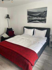 布拉索夫Maple Lodge Apartments的一间卧室配有一张带红色毯子的大床