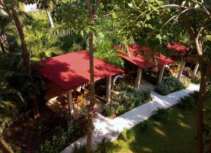 阿卡普尔科Hotel Casa de Lirio Diamante的红屋顶,树木和植物的度假胜地