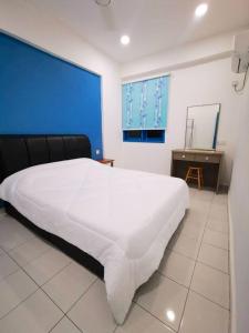 瓜埠Bleu Martin Families Suite Apartment的卧室配有一张白色大床和蓝色的墙壁