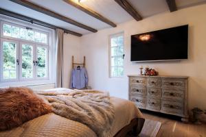 伦达瓦Vila Vilma Vineyard Cottage的卧室配有一张床,墙上配有电视