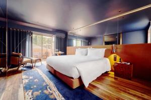 加亚新城The Lodge Hotel的一间大卧室,配有一张白色的大床和一张桌子