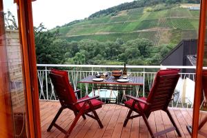 赖尔Casa Barzen - Stilvoll Urlauben an der Mosel的观景甲板上配有一张桌子和两把椅子
