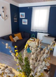 普鲁斯基Cztery Pory Warmii Pluski pokoje do wynajęcia的客厅拥有蓝色的墙壁和蓝色的沙发