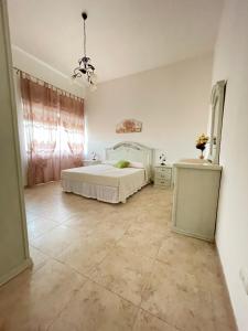 马丁纳弗兰卡Masseria Paglieroni的卧室配有白色的床,铺有瓷砖地板。