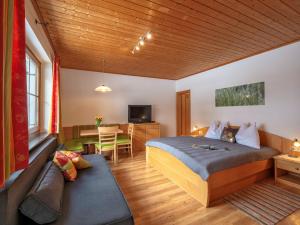 巴特霍夫加施泰因兰德施魏格尔公寓的一间卧室配有一张床和一个沙发