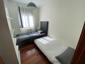 维耶拉Apartamento tranquilo Vielha Centro con Parking Gratuito的一间小卧室,配有两张床和窗户