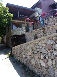奥赫里德Guest House Stevovski的鲜花屋前的石墙
