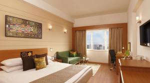 海得拉巴海得拉巴泰克城市柠檬树普瑞米尔酒店的配有一张床和一张书桌的酒店客房