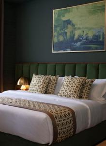 库塔伊西Grand Opera Hotel的一张带绿色床头板和枕头的大床
