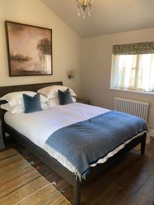 博利厄Pear Tree Cabin的一间卧室配有一张带蓝色毯子的大床