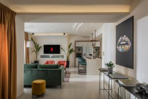 赫索尼索斯Maison De Mare, 4BR Central Luxury Beach Residence的一间带绿色沙发的客厅和一间厨房