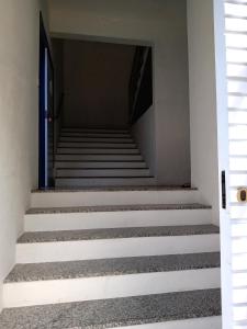 欧鲁普雷图Casa nova com suítes amplas的通往蓝色门的楼梯