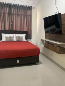 皮乌拉Hotel Calmelia的一间卧室配有红色的床和一台平面电视