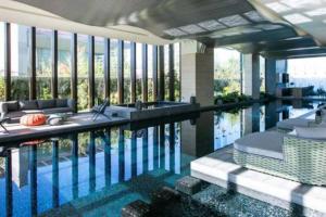 墨西哥城Orange & Green Apartment - HP Sur的一个带椅子和桌子的游泳池以及一些窗户